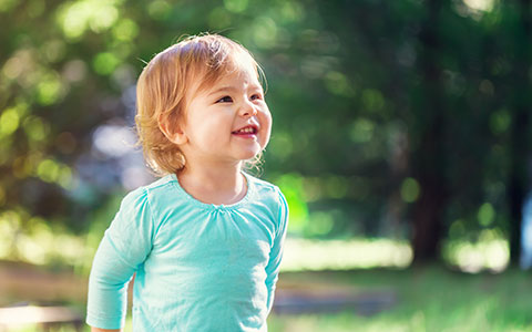 Happy little girl in turqoise smiling